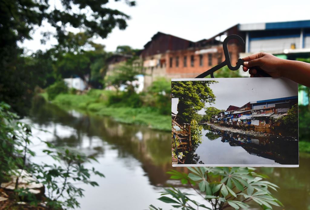 In this photograph taken on January 31, 2017, a photograph of the previous condition of Tongkol kampung is juxtaposed against its current condition in Jakarta. AFP / Bay Ismoyo 
