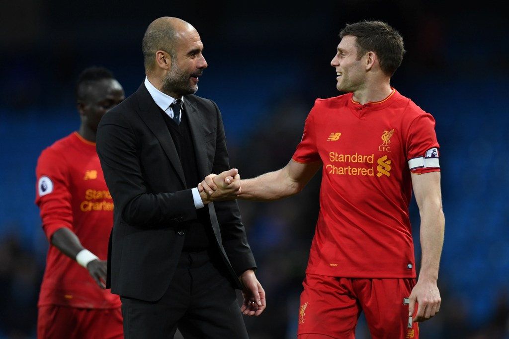 Manchester City's Spanish manager Pep Guardiola (L) speaks with Liverpool's English midfielder James Milner after the English Premier League football match between Manchester City and Liverpool at the Etihad Stadium in Manchester, north west England, on M