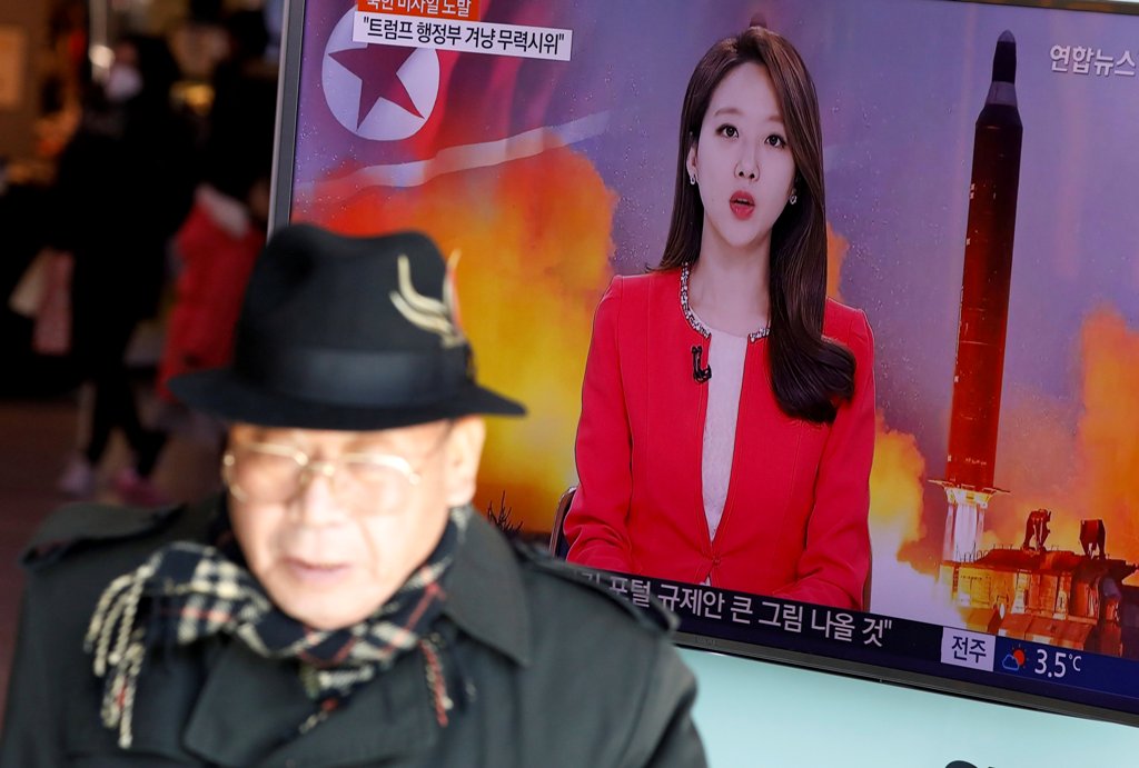 FILE PHOTO: A man walks past a TV screen broadcasting a news report on North Korea firing a ballistic missile into the sea off its east coast, at a railway station in Seoul, South Korea, February 12, 2017. REUTERS/Kim Hong-JI/File Photo

