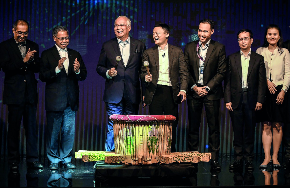 Malaysia's Prime Minister Najib Razak (third left) and China's Alibaba Group founder and executive chairman Jack Ma (fourth right) smile after hitting a gong during the launching of the country's Digital-Free Trade Zone in Kuala Lumpur, yesterday.