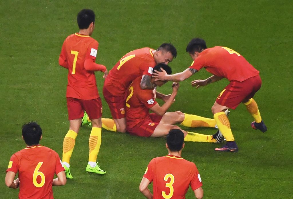 Chinese players celebrate after Yu Dabao (top C) scored during their World Cup football qualifying match against South Korea in Changsha, China's central Hunan province, on March 23, 2017. / AFP / GREG BAKER
