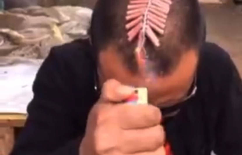 A screenshot from Kuaishou shows a man setting off firecrackers on his head. Kuaishou, which runs a live-streaming social media platform similar to Twitter Inc.’s Periscope and Facebook Inc.’s Instagram, was founded in 2011, its website shows. (Image cour