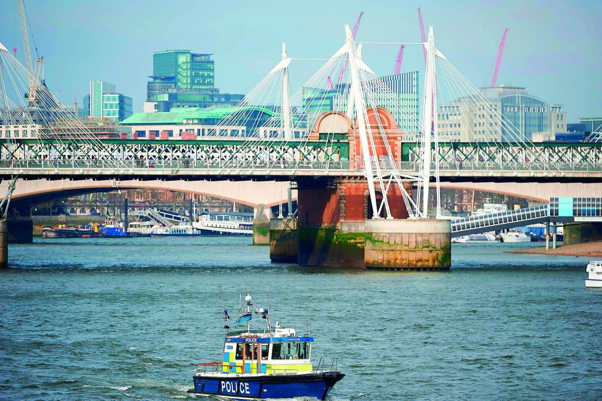 Police boats patrol the river Thames near the Houses of Parliament in London, yesterday. Eight people have been arrested in London and Birmingham over the terror attack at the British parliament.