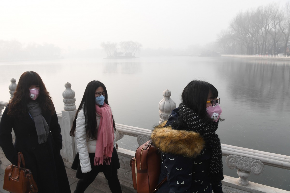Chinese women wear masks on a heavily polluted day in Beijing on January 1, 2017 (AFP / GREG BAKER) 