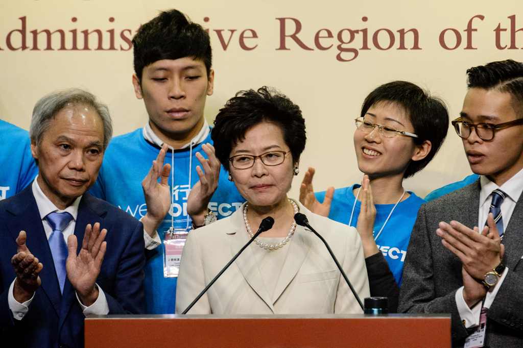 Hong Kong's new chief executive Carrie Lam (C) reacts at a press conference after she won the Hong Kong chief executive election in Hong Kong on March 26, 2017.   AFP / ANTHONY WALLACE
