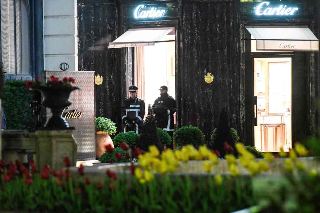 Monaco's police officers stand guard in front of the Cartier jewellery boutique after it was robbed in downtown Monaco on March 25, 2017. One robber was arrested by Police, as two remained on the run.  AFP /  YANN COATSALIOU
