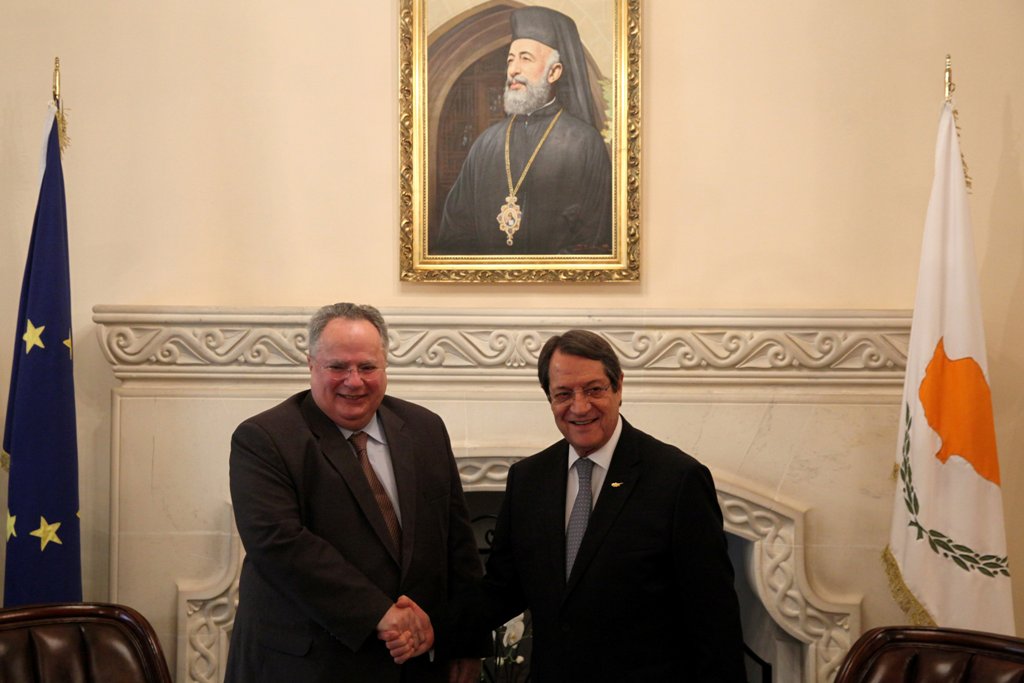 Cypriot President Nicos Anastasiades (R) and Greek Foreign Minister Nikos Kotzias shake hands during a meeting at the presidential palace in Nicosia, Cyprus March 27, 2017. REUTERS/Yiannis Kourtoglou

