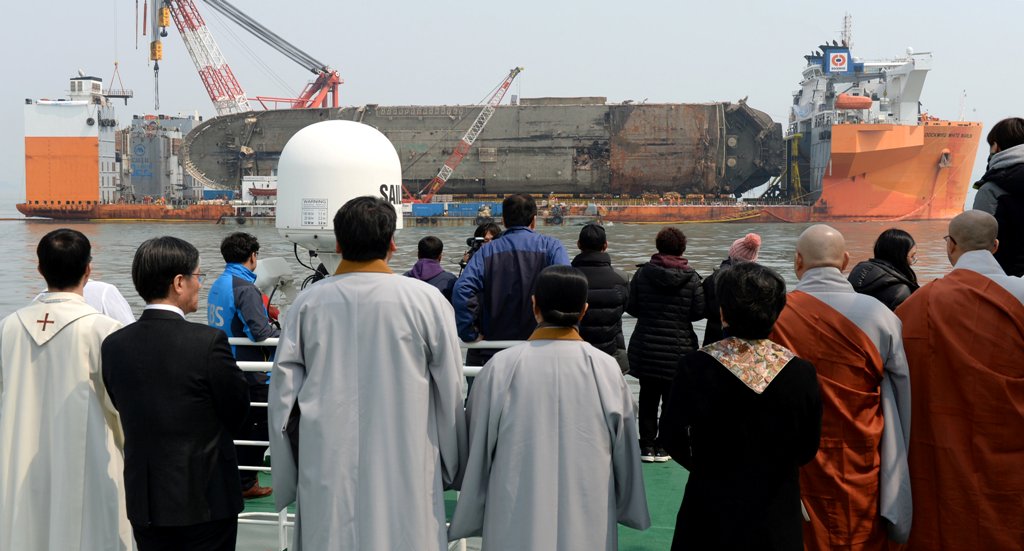 Family members of victims onboard the sunken ferry Sewol and religious people look on during a memorial ceremony at the sea off Jindo, South Korea, March 28, 2017. Yonhap via REUTERS.