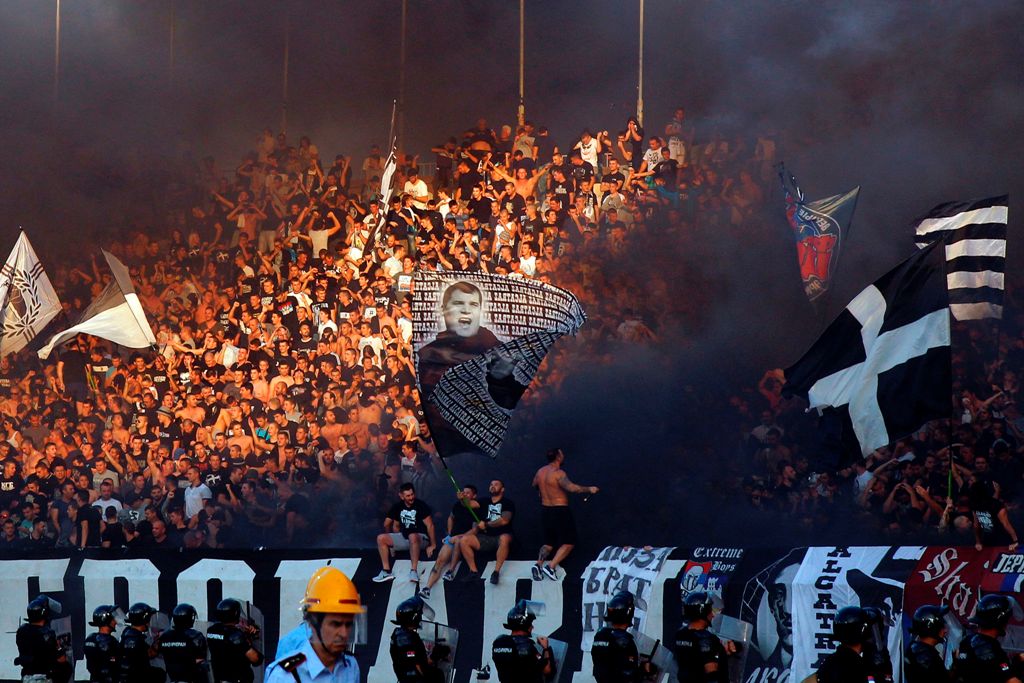 (FILES) This file photo taken on September 17, 2016 in Belgrade shows supporters of Partizan Belgrade throwing smoke grenades on the tribunes during the Serbian first league match between Red Star and Partizan. AFP / PEDJA MILOSAVLJEVIC
