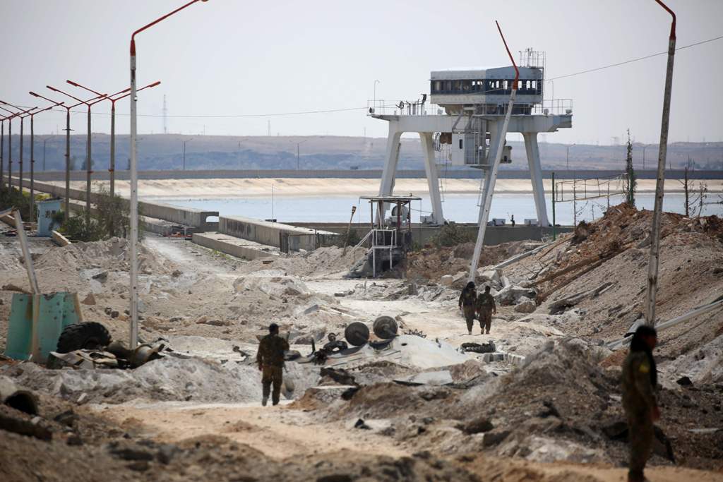 Members of the US-backed Syrian Democratic Forces (SDF), made up of an alliance of Arab and Kurdish fighters, inspect the Tabqa dam on March 27, 2017, which has been recently partially recaptured, as part of their battle for the jihadists' stronghold in n