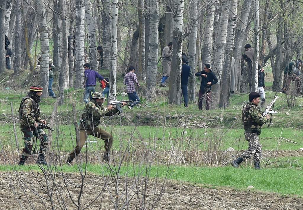 Kashmiri protestors run after Indian security personnel used live ammunition near the site of a gun battle between suspected rebels and Indian soldiers in Chadoora, in the Badgam district of Srinagar, on March 28, 2017.  AFP / Tauseef MUSTAFA
