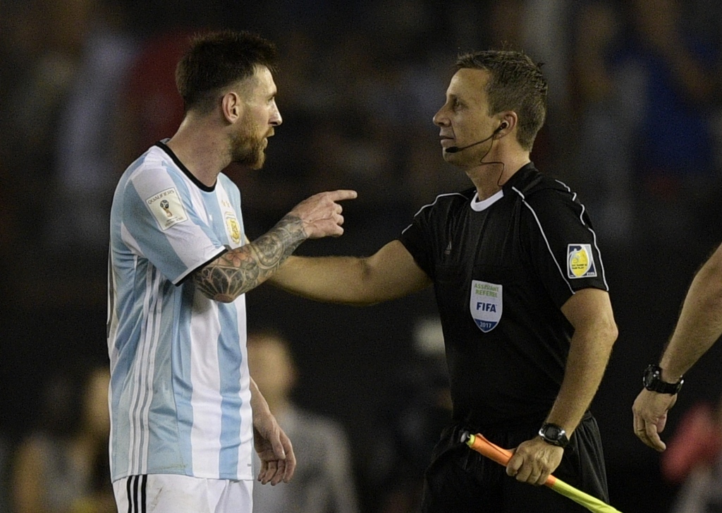 Argentina's forward Lionel Messi (L) argues with first assistant referee Emerson Augusto de Carvalho at the end of their 2018 FIFA World Cup Russia South American qualifier football match against Chile, at the Monumental stadium in Buenos Aires, on March 