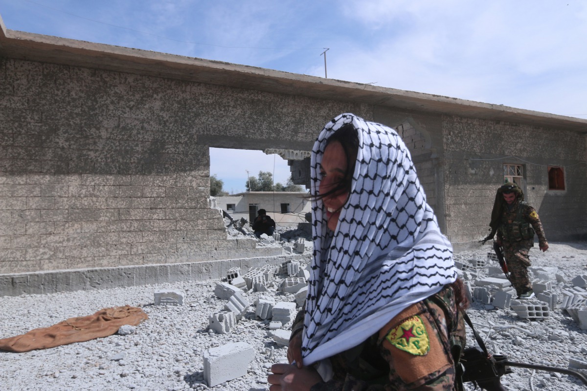 Syrian Democratic Forces (SDF) fighters walk near rubble of damaged houses east of Raqqa city, Syria March 26, 2017. REUTERS/Rodi Said