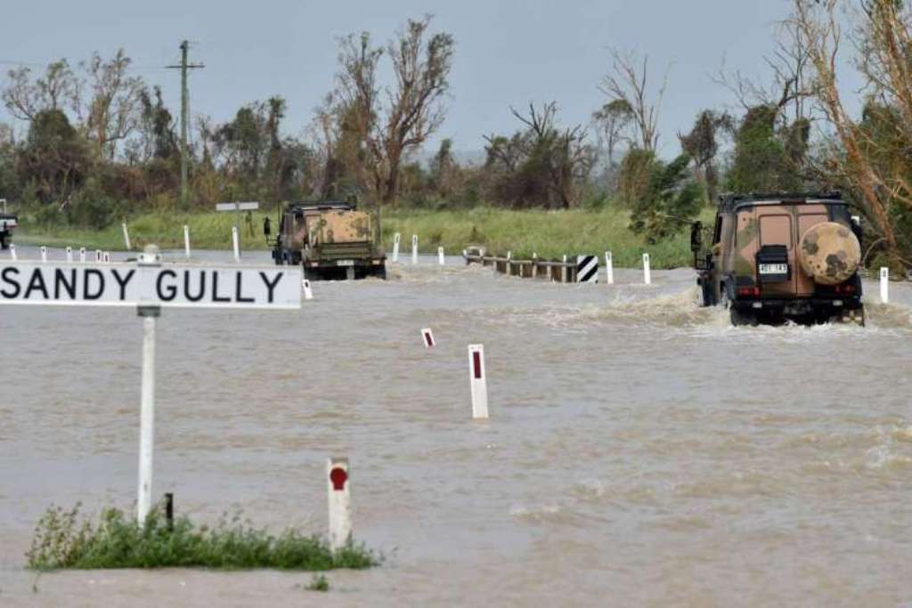 Army vehicles driving through floodwaters near the Queensland town of Bowen on March 29, 2017, after the area was hit by Cyclone Debbie.PHOTO: AFP.