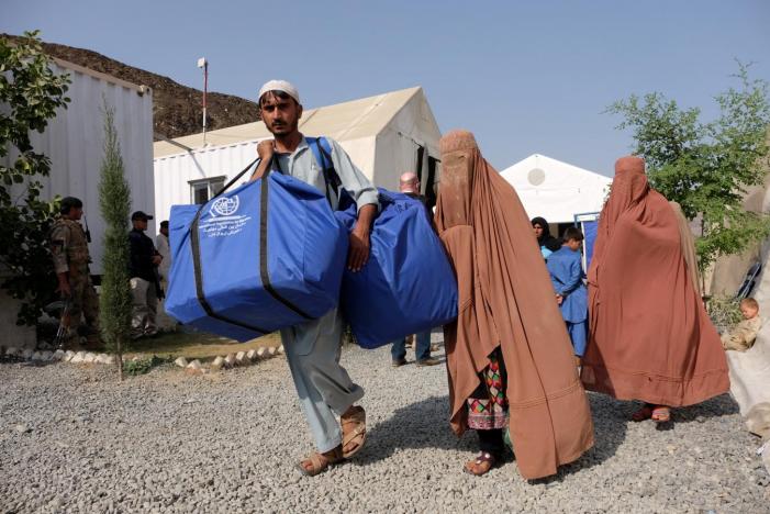 FILE PHOTO: An Afghan family who were living as refugees in Pakistan carries bundles of supplies at a humanitarian aid station in Torkham, Afghanistan, October 22, 2016 (REUTERS / Josh Smith) 