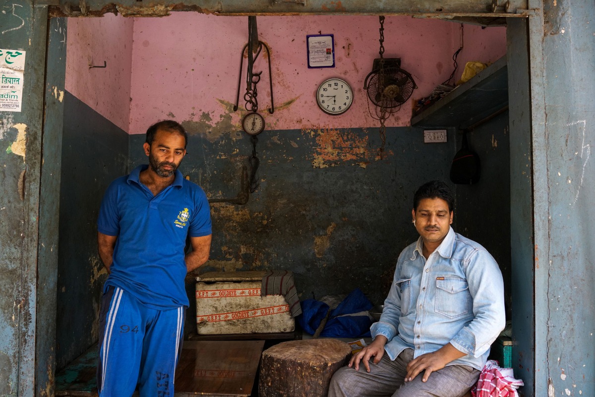 In this photograph taken on March 25, 2017, Indian butcher Riyaz Babu Qureshi (R) sits in his empty shop in the old quarters of Meerut. A zealous campaign to protect cows -- considered sacred by Hindus -- by a new right-wing government in Uttar Pradesh st