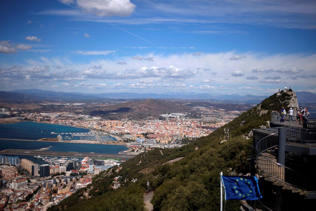 A general view shows the Spanish city of La Linea de la Concepcion (rear) and the tarmac of the Gibraltar International Airport (bottom L) while tourists stand on the top of the Rock (R) next to the European Union flag, in the British overseas territory o