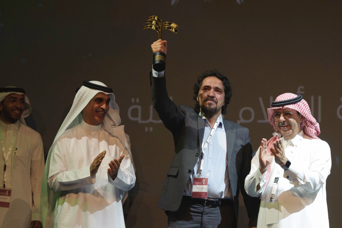 Saudi actor Mohammed Al-Qess waves his award for best actor in the film 