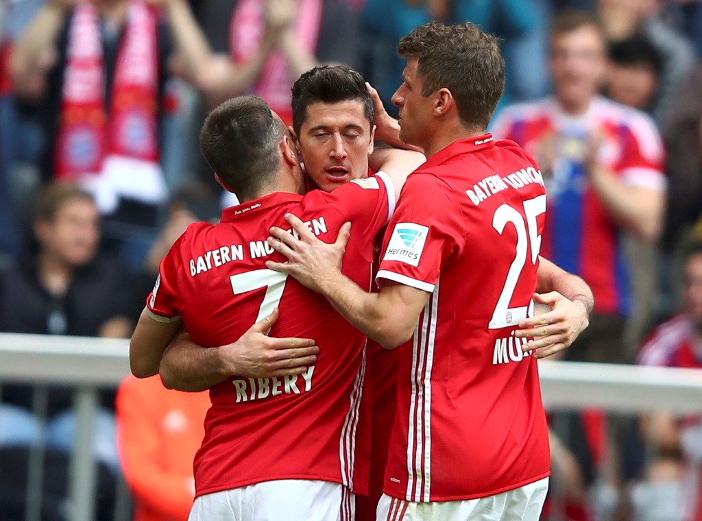 Bayern Munich's Robert Lewandowski celebrates with his teammates Franck Ribery and Thomas Mueller after scoring a goal. REUTERS/Michael Dalder  
