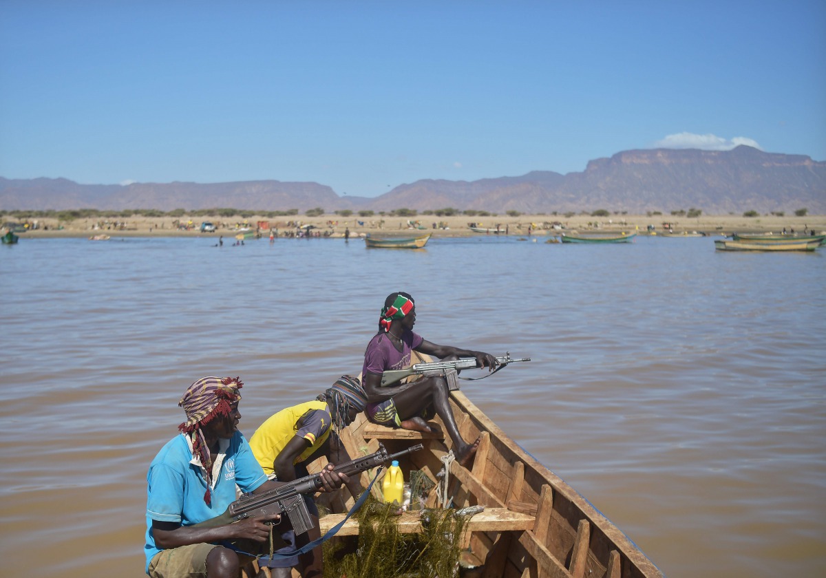 Armed fishermen from Kenya's Turkana county return from a fishing expedition aboard a boat on March 24, 2017 near Lowarengak, on the western shores of Lake Turkana, northern Kenya. Lake Turkana has gradually receded in recent years leading to diminished f