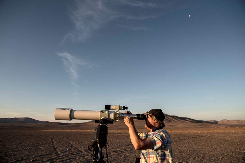 French astronomer Christian Nitschelm observes the sky with his telescope in Yungay, Atacama desert, some 80 kilometres south of Antofagasta, Chile on March 7, 2017. AFP / Martin Bernetti 