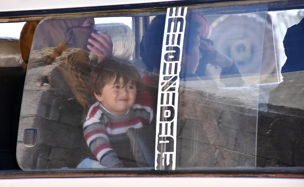 Syrians who fled the city of Aleppo due to the fighting are seen inside a vehicle as they prepare to return to their hometown under the supervision of members of the Russian Military police in the northern city of Manbij on April 5, 2017. / AFP / George O