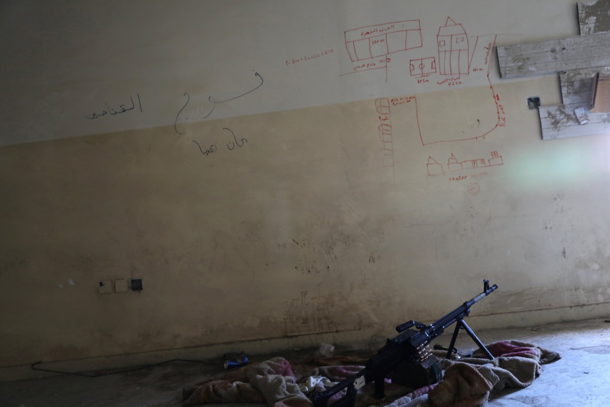 A machine gun is seen on the floor next to a map drawn to show distances, on the wall of a sniper's nest in a building controlled by Iraqi forces fighting the Islamic State in Mosul, Iraq, April 6, 2017. REUTERS/Andres Martinez Casares