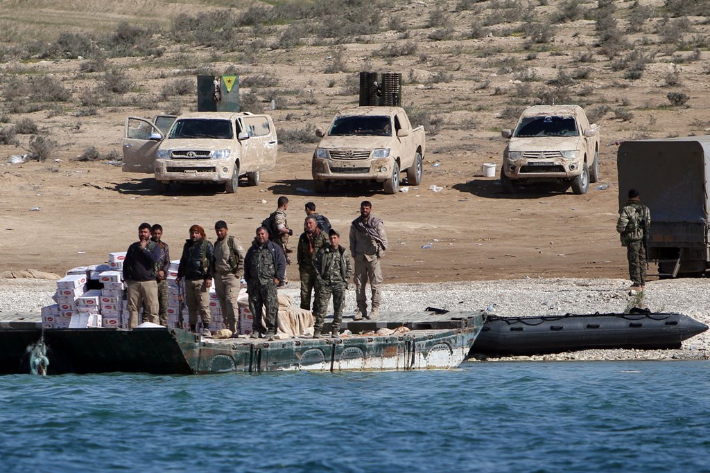 Syrian Democratic Forces (SDF) fighters stand near food supplies on the bank of the Euphrates river, west of Raqqa city, Syria April 10, 2017. REUTERS/Rodi Said
