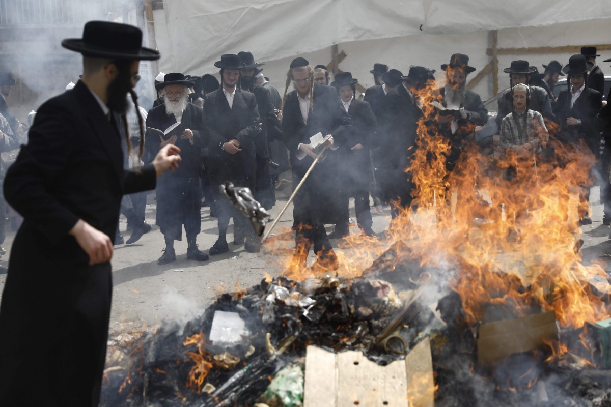 Ultra-Orthodox Jewish men burn leavened items during the Biur Chametz ritual on April 10, 2017 in Jerusalem on the eve of the Jewish Pesach (Passover) holiday, which begins at sunset today. Due to the haste with which the Jews left Egypt, the bread they h