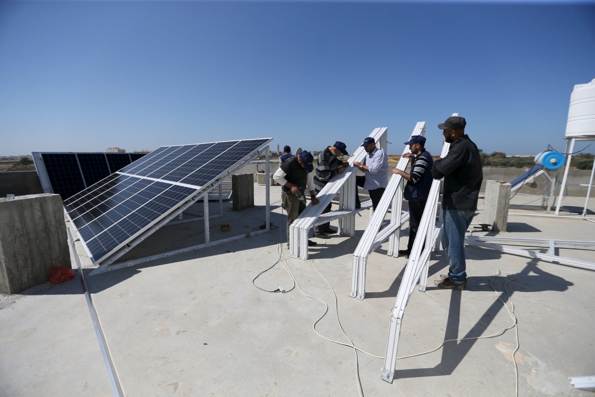 FILE PHOTO: Palestinian workers install solar panels atop the roof of a medical centre in Gaza City, March 1, 2016 (REUTERS / Ibraheem Abu Mustafa) 