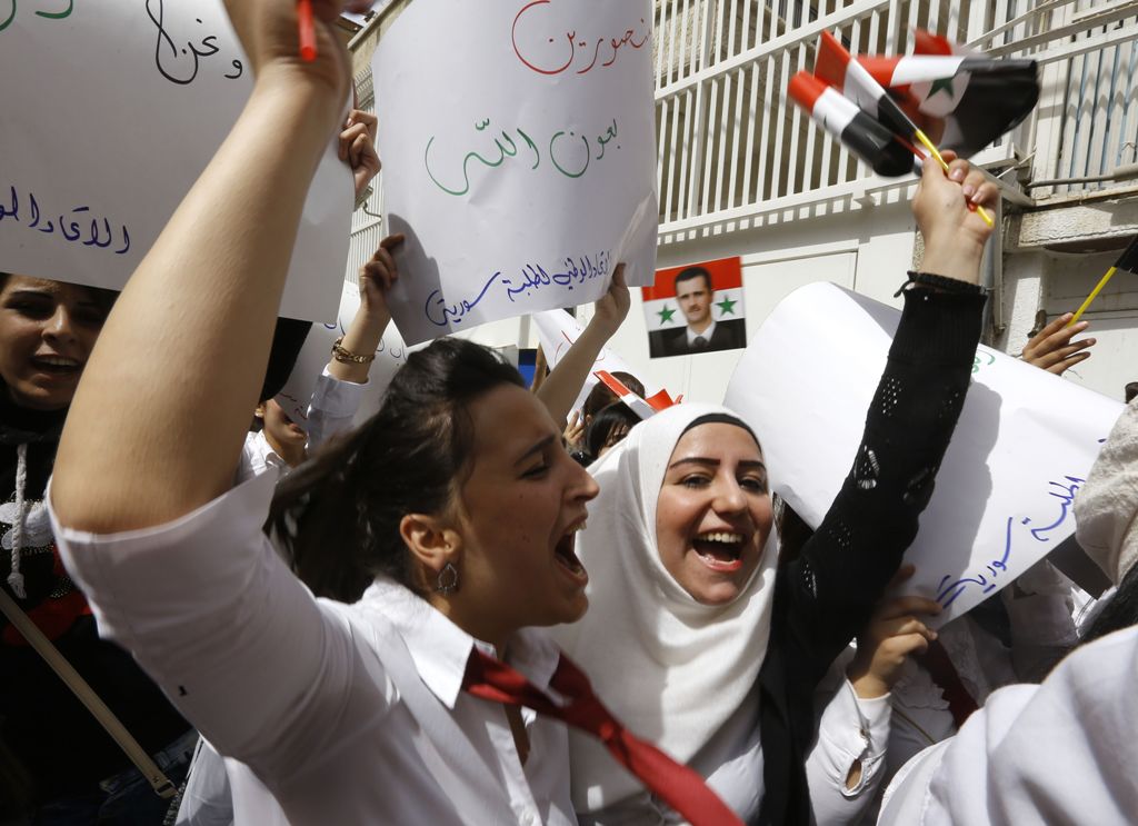 Syrian protestors take part in a demonstration outside the United Nation's (UN) office in the capital Damascus, on April 11, 2017, in support of their country's President Bashar al-Assad.  AFP / Louai Beshara
