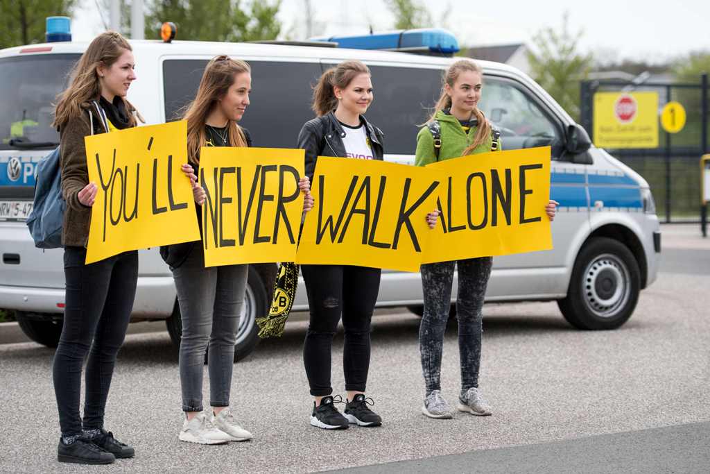 Supporters of German first division Bundesliga football club Borussia Dortmund hold up posters reading 
