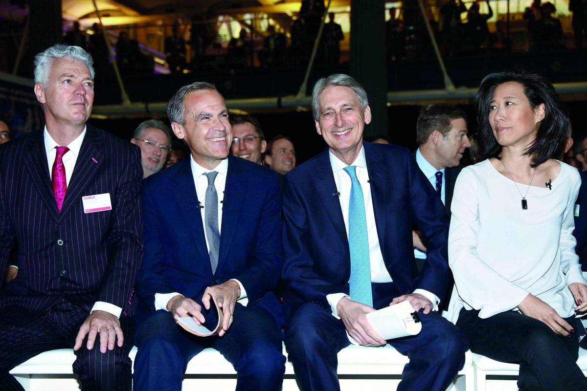 Britain's Chancellor of the Exchequer, Philip Hammond (second right) and Governor of the Bank of England, Mark Carney (third right) gesture during the International Fintech Conference in London