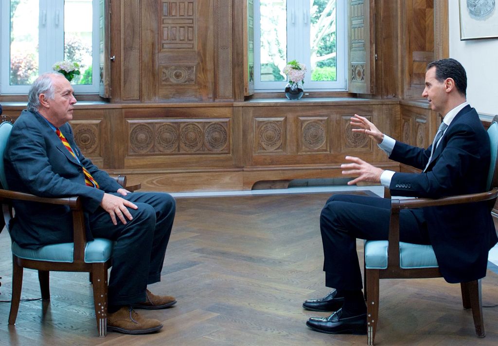 A handout picture released by the Syrian presidency's press office shows Syrian President Bashar al-Assad (R) during an interview with AFP's Beirut bureau chief Sammy Ketz in the capital Damascus, on April 12, 2017. / AFP / Syrian Presidency Press Office 