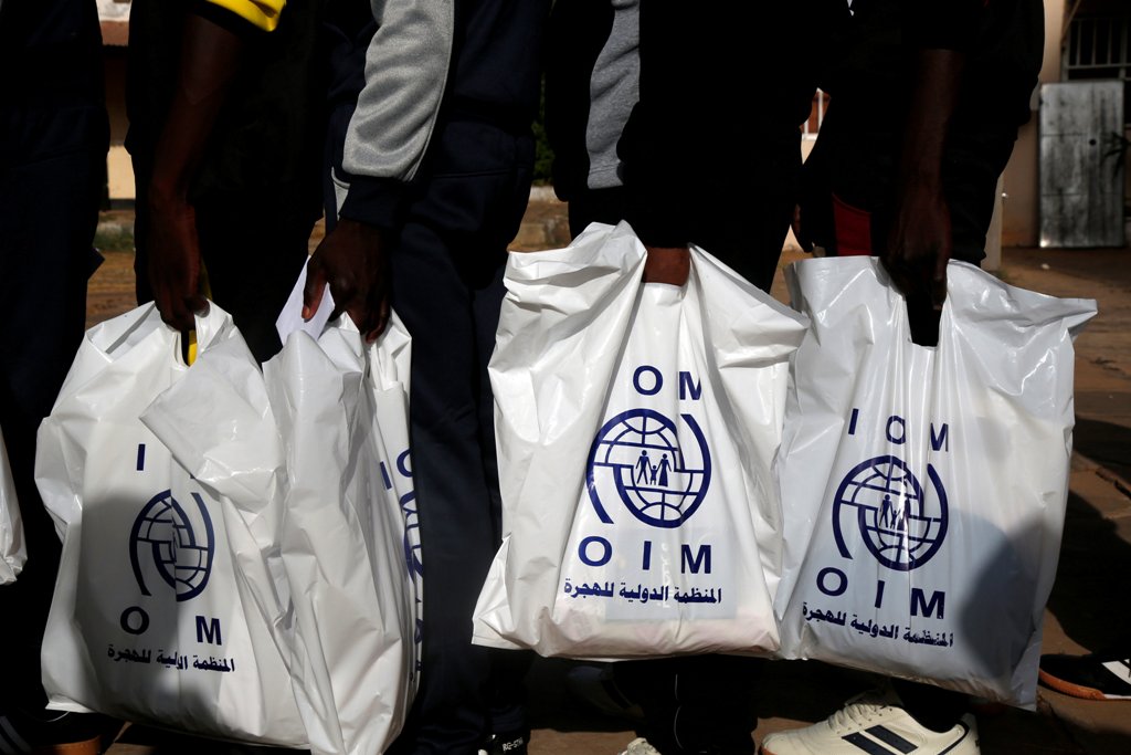 (File Photo) Gambian migrants who voluntarily returned from Libya stand in line with plastic bag from the International Organization for Migration (IOM) as they wait for registration at the airport in Banjul, Gambia April 4, 2017. REUTERS/Luc Gnago