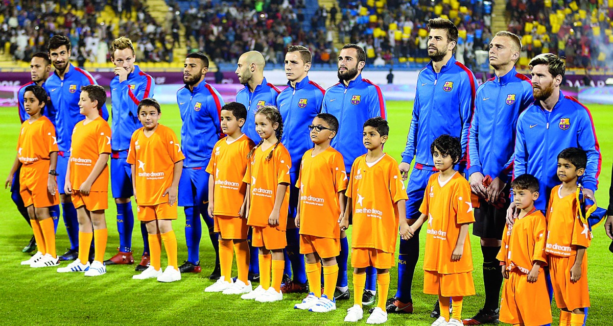 Kids representing Save the Dream accompany Barcelona players ahead of their match against Saudi Arabia's Ahli in Doha, in this December 2016 file photo.  