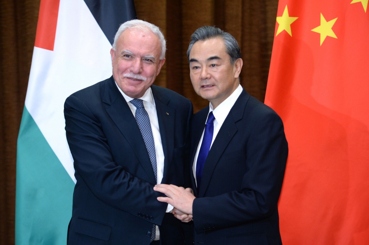 Chinese Foreign Minister Wang Yi (R) shakes hands with his Palestinian counterpart Riyad Al-Maliki before their meeting at the Ministry of Foreign Affairs in Beijing on April 13, 2017. / AFP / POOL / Parker Song