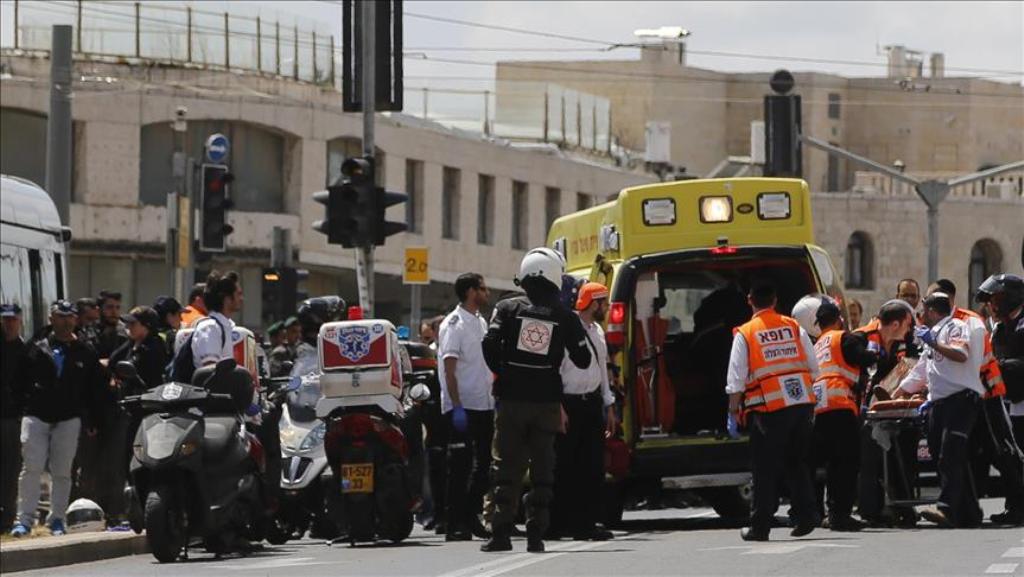 Israeli health team workers treat the wounded British tourist after he was attacked with a knife at a tramway in Jerusalem on April 14, 2017. ( Mostafa Alkharouf - Anadolu Agency ).