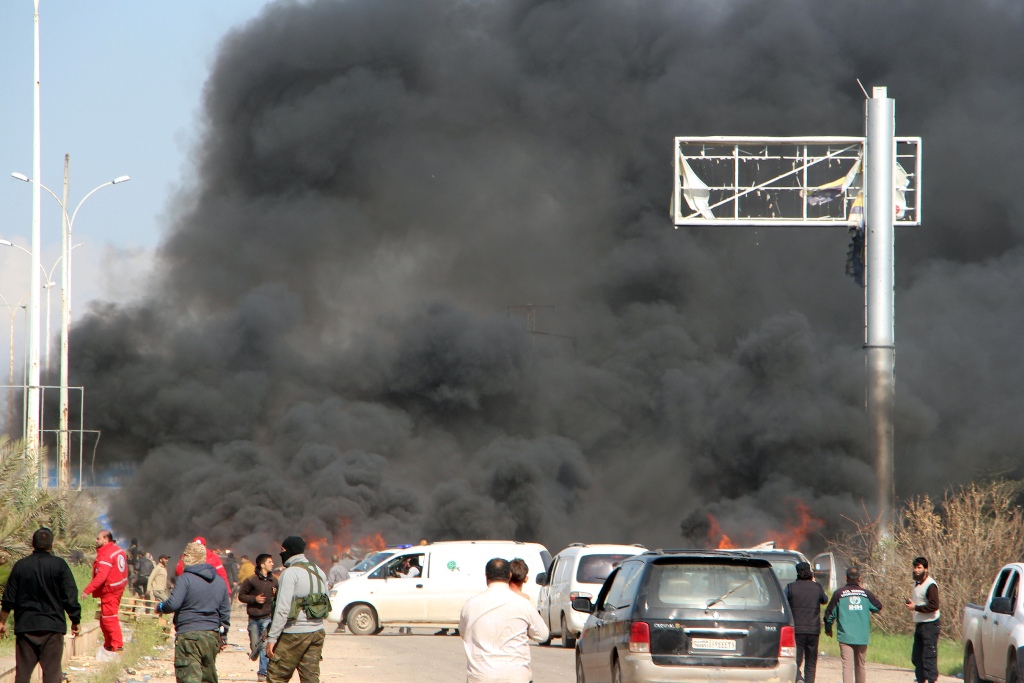 A picture taken on April 15, 2017, shows smoke billowing following a suicide car bombing in Rashidin, west of Aleppo, that targeted buses carrying Syrians evacuated from two besieged government-held towns of Fuaa and Kafraya.  AFP / Ibrahim YASOUF
