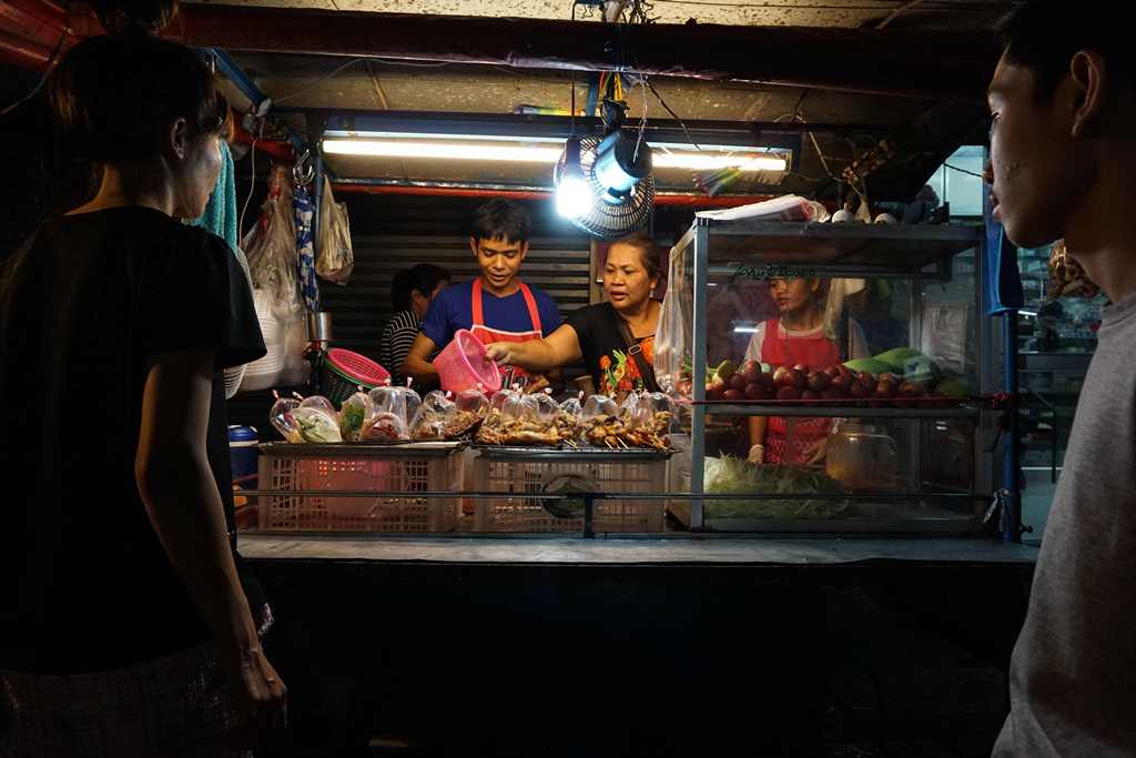 This photo taken on April 17, 2017 shows a family preparing food for customers at a street food stall in the Phrakanong district of Bangkok. AFP / LILLIAN SUWANRUMPHA
