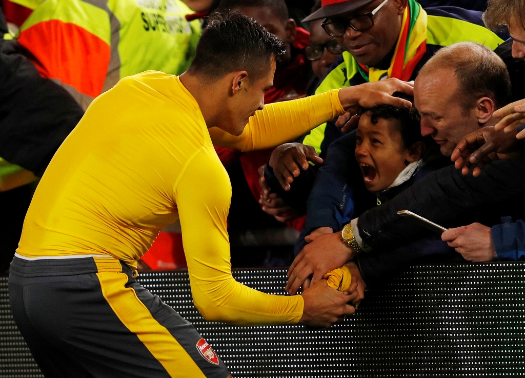 Arsenal's Alexis Sanchez gives his shirt to a young fan after the game. via Reuters / Lee Smith Livepic 