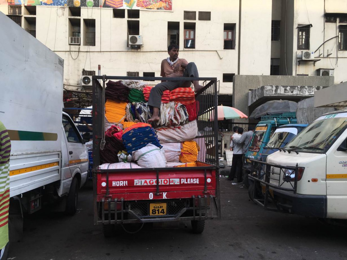 A man rests on a pile of fabric in the textile market of Surat, a key textile hub of India and the largest manufacturer of synthetic fabric in the country. India exports $6 billion worth of synthetic fabric annually. TRF / Roli Srivastava