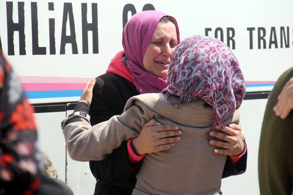 A Syrian woman, who was wounded in a car bomb blast on April 15 while waiting at a transit point during their evacuation from the sieged government-held towns of Kufraya and Fuaa in a deal made between the government and the rebels, greets a recently evac