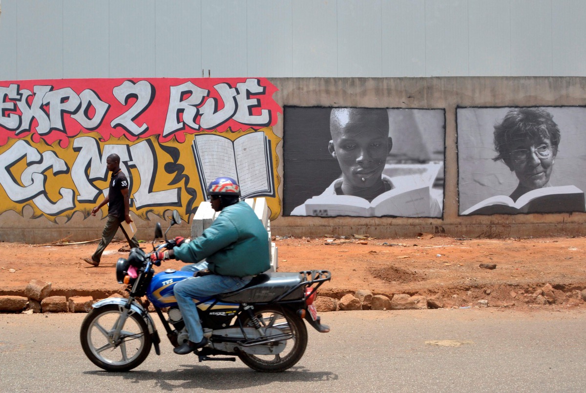 A moto drives past posters promoting the 