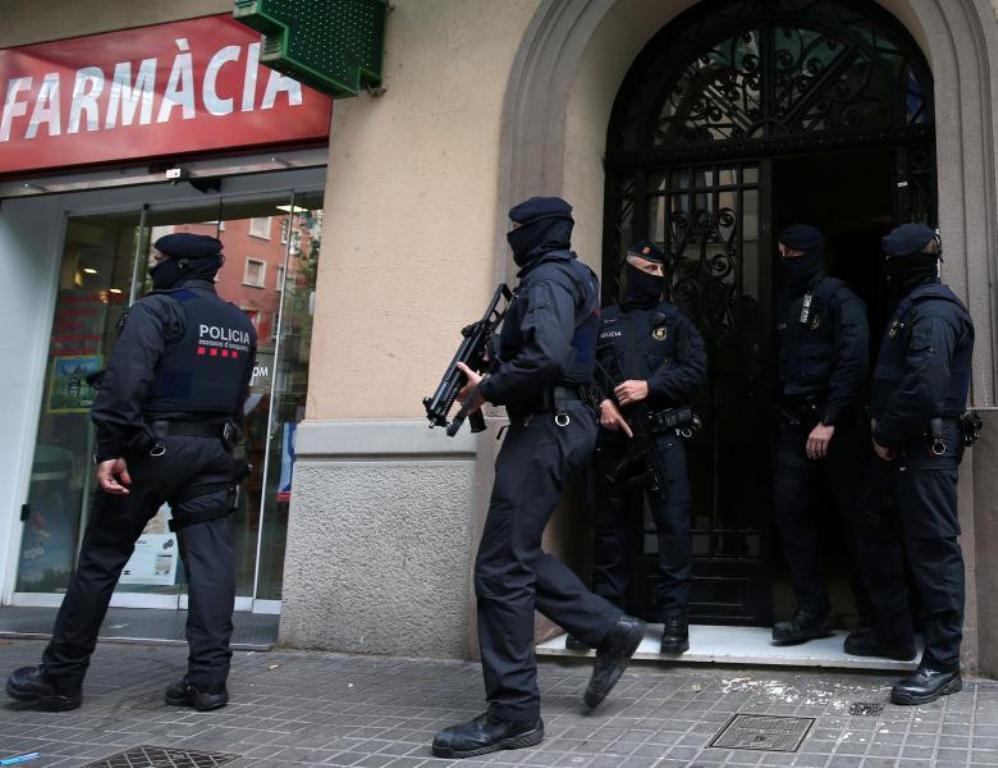 Spanish police stand guard outside an apartment building during a sweeping operation at some 12 locations against Islamist militants, in which eight people were arrested, in Barcelona, Spain, April 25, 2017. REUTERS/Albert Gea.