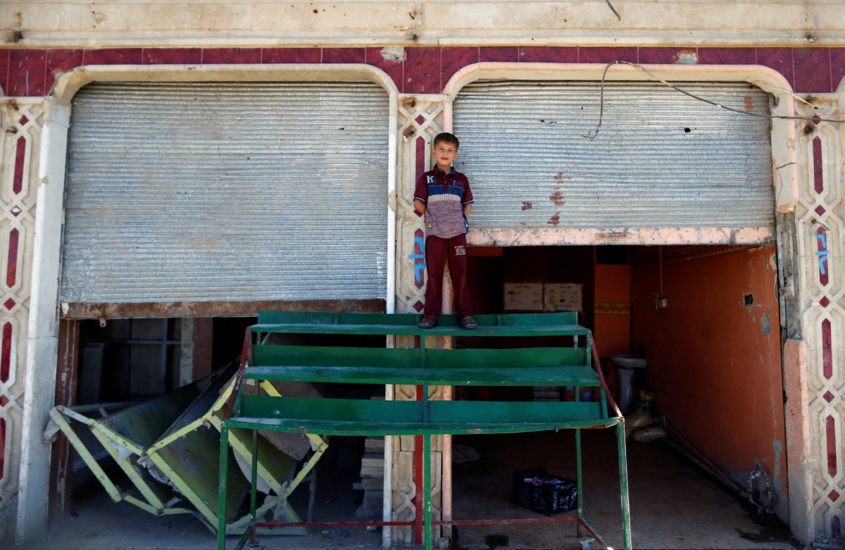 A displaced Iraqi boy stands as he plays outside a damaged buliding in western Mosul, Iraq, April 25, 2017. REUTERS/Ahmed Jadallah