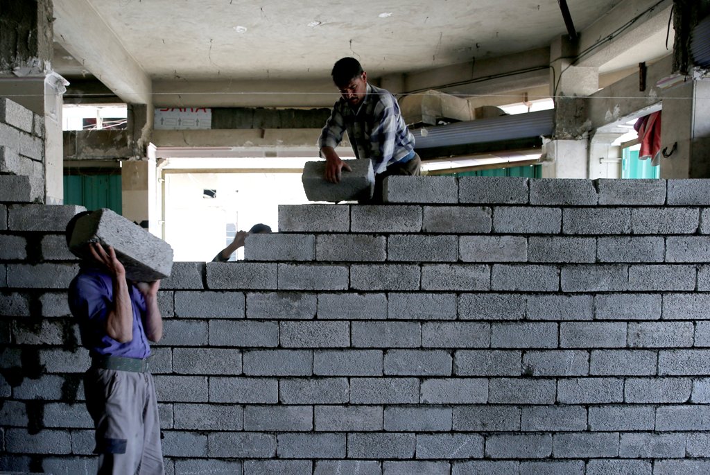 Workers rebulid a shop that was destroyed during fighting between Iraqi forces and Islamic state fighters, eastern Mosul, Iraq, April 21, 2017. REUTERS/ Muhammad Hamed