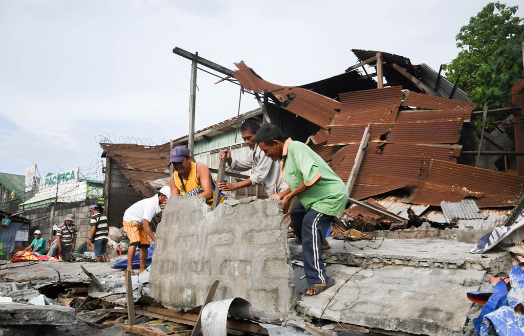 Workers remove debris from a collapsed house after a 6.8-magnitude earthquake hit General Santos City, in southern island of Mindanao on April 29, 2017.   AFP / EDWIN ESPEJO
