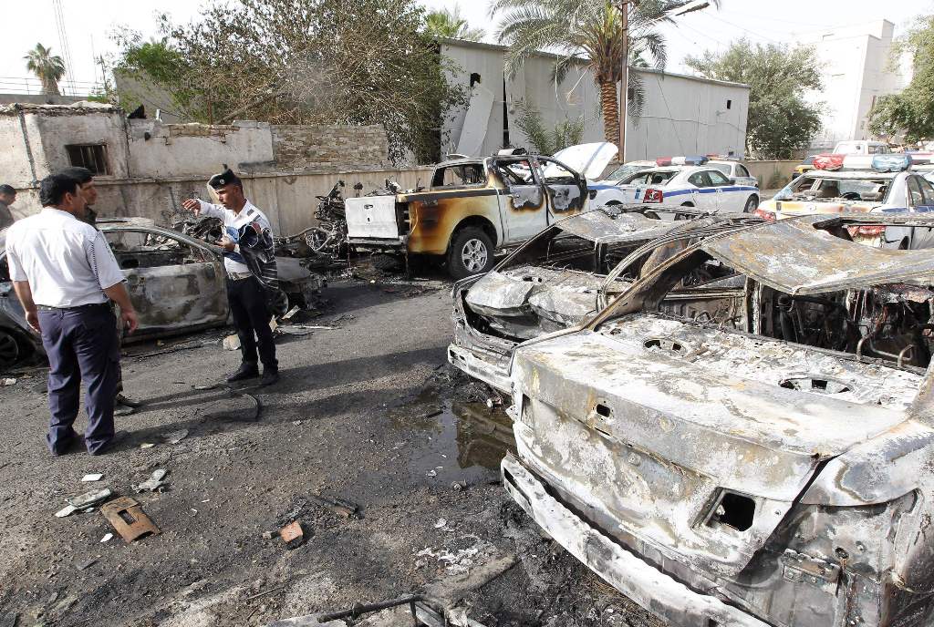 Iraqi policemen check the site of a blast which took place the previous day in the Iraqi capital Baghdad on April 29, 2017. A car bomb attack on the traffic police compound in central Baghdad killed at least three people and wounded seven, security and me