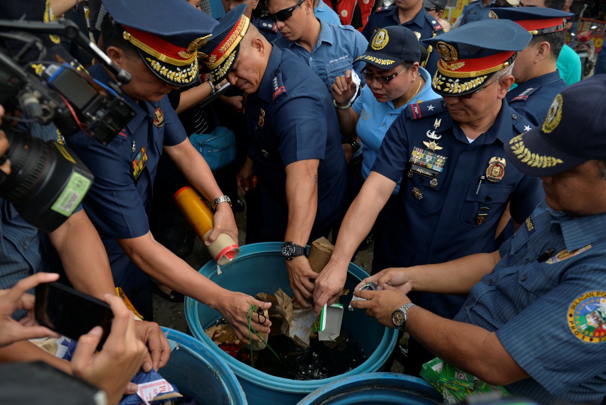 FILE PHOTO: Philippine National Police Director General Ronald Dela Rosa along with other officials dunks confiscated illegal firecrackers into a tub of water to render them unusable, December 29, 2016 (REUTERS / Ezra Acayan) 